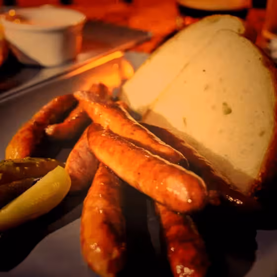 a plate of gherkin, sausages and bread in a lviv bistro