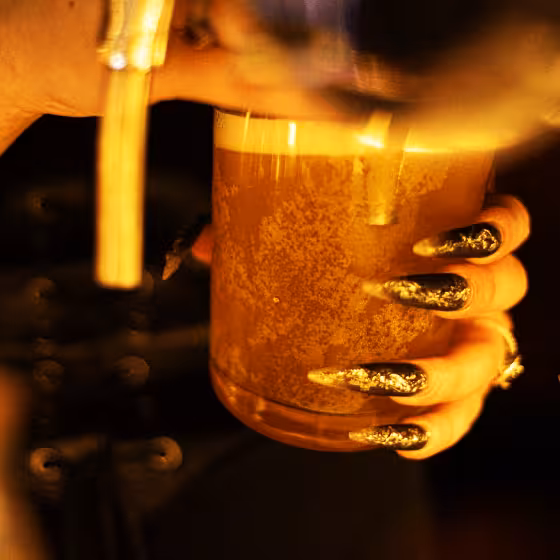 a girl pouring a glass of cider in lviv old town