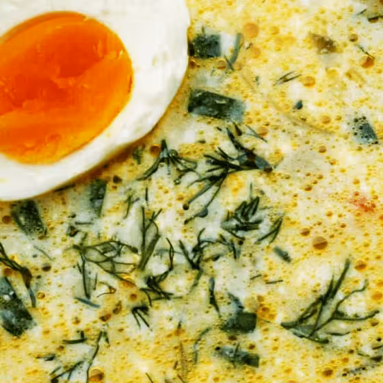 an appetizing bowl of green borscht with egg and spinach